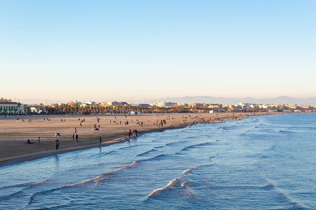 La playa de la Malvarrosa a última hora de la tarde, con el paseo marítimo y el skyline de Valencia al fondo